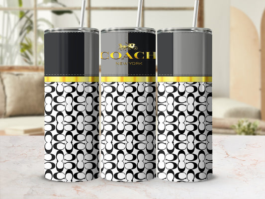 Coach New York tumblers with black and white interlocking C pattern on a marble surface.