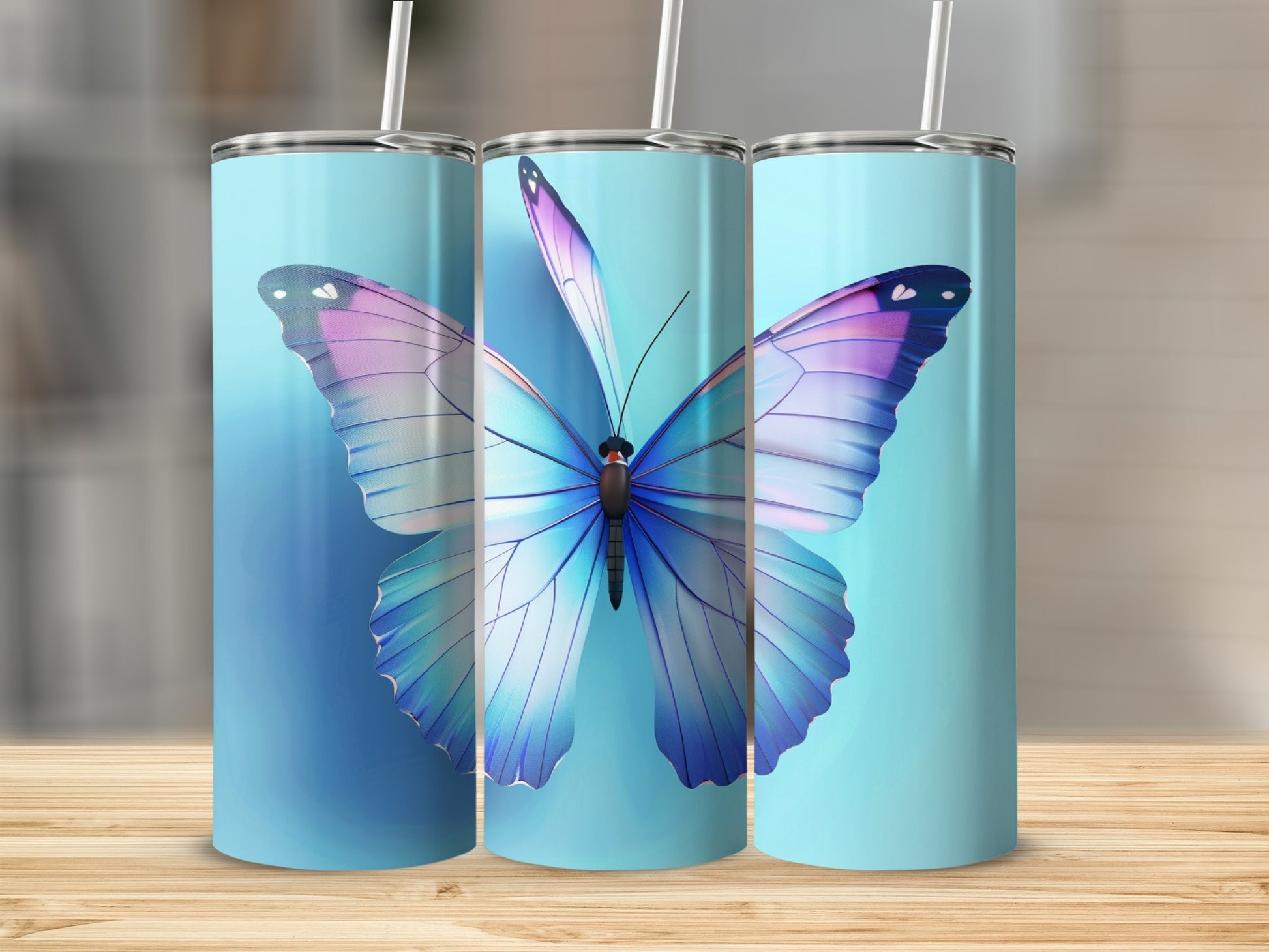 Blue tumbler with large iridescent butterfly and straw on wooden surface.