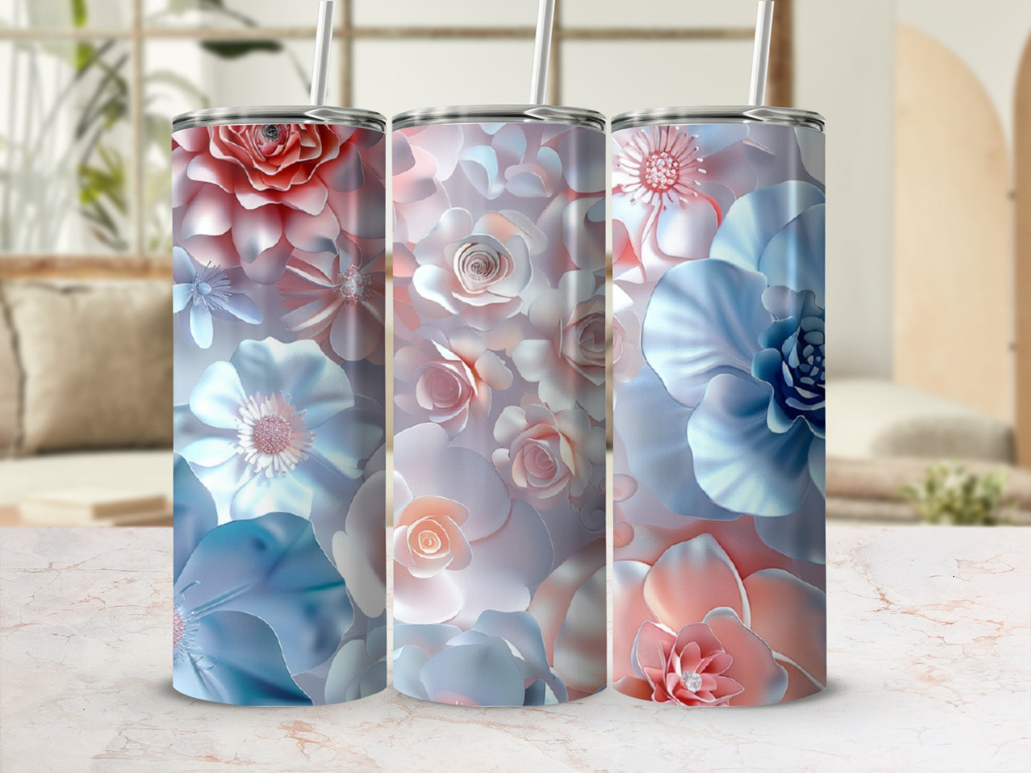 Three floral-patterned tumblers with straws in soft blues and pinks.