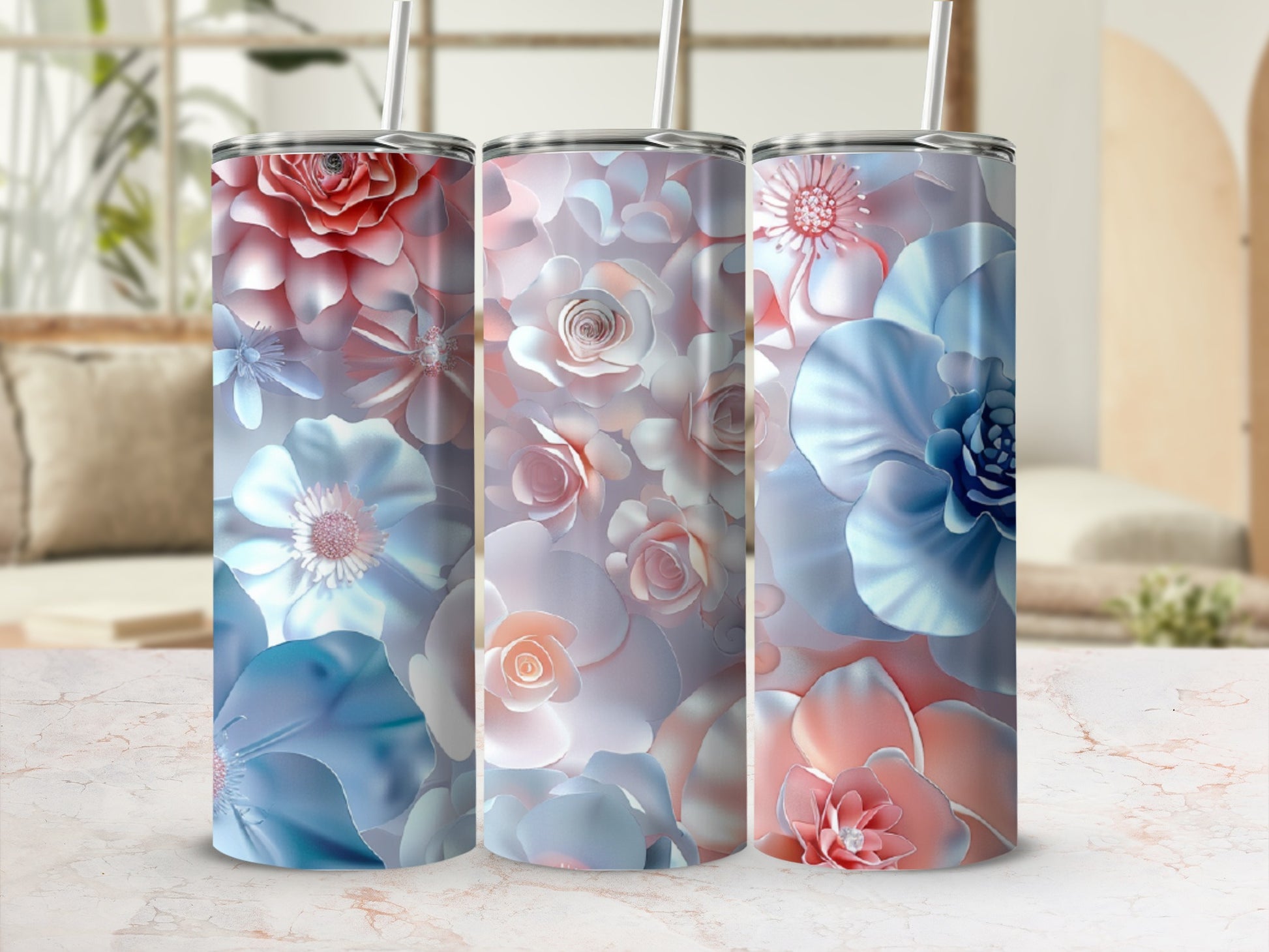 Three floral-patterned tumblers with straws in soft blues and pinks.