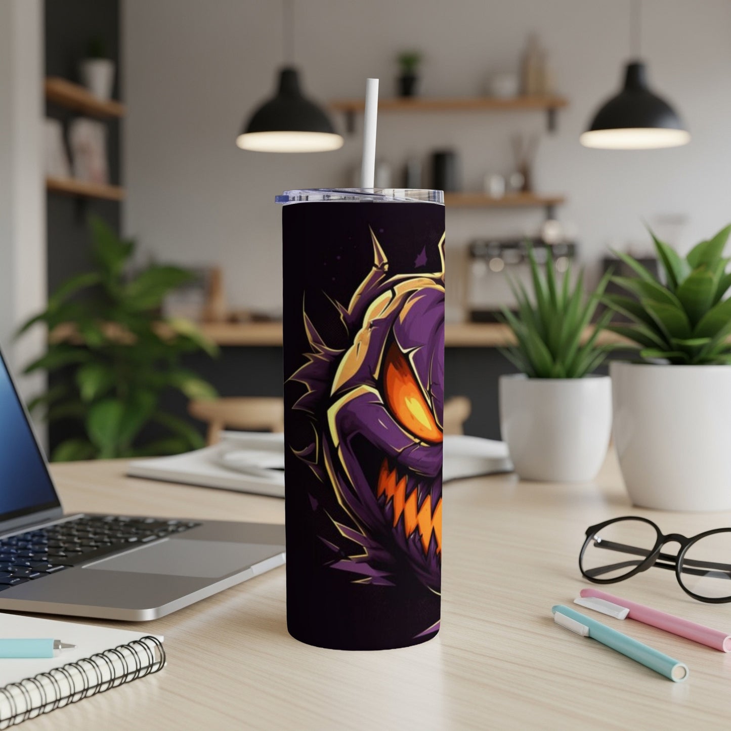Dark tumbler with purple monster face design and white straw on a desk.