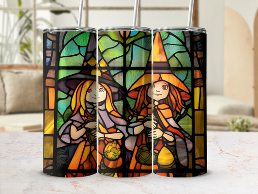 Three stained-glass tumblers with witches and pumpkins in a window frame.