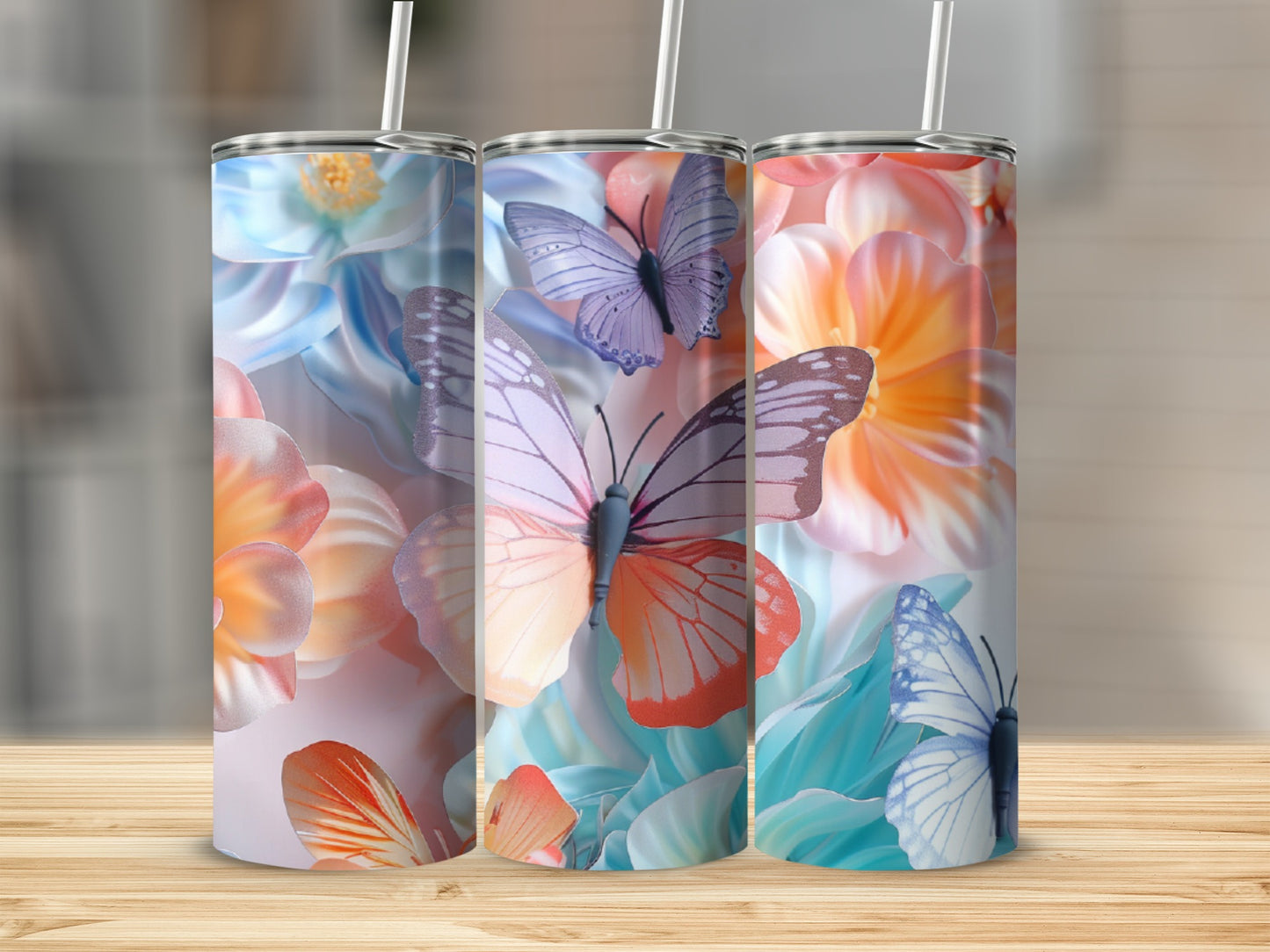 Three tumblers with floral and butterfly designs stand on a wooden surface.