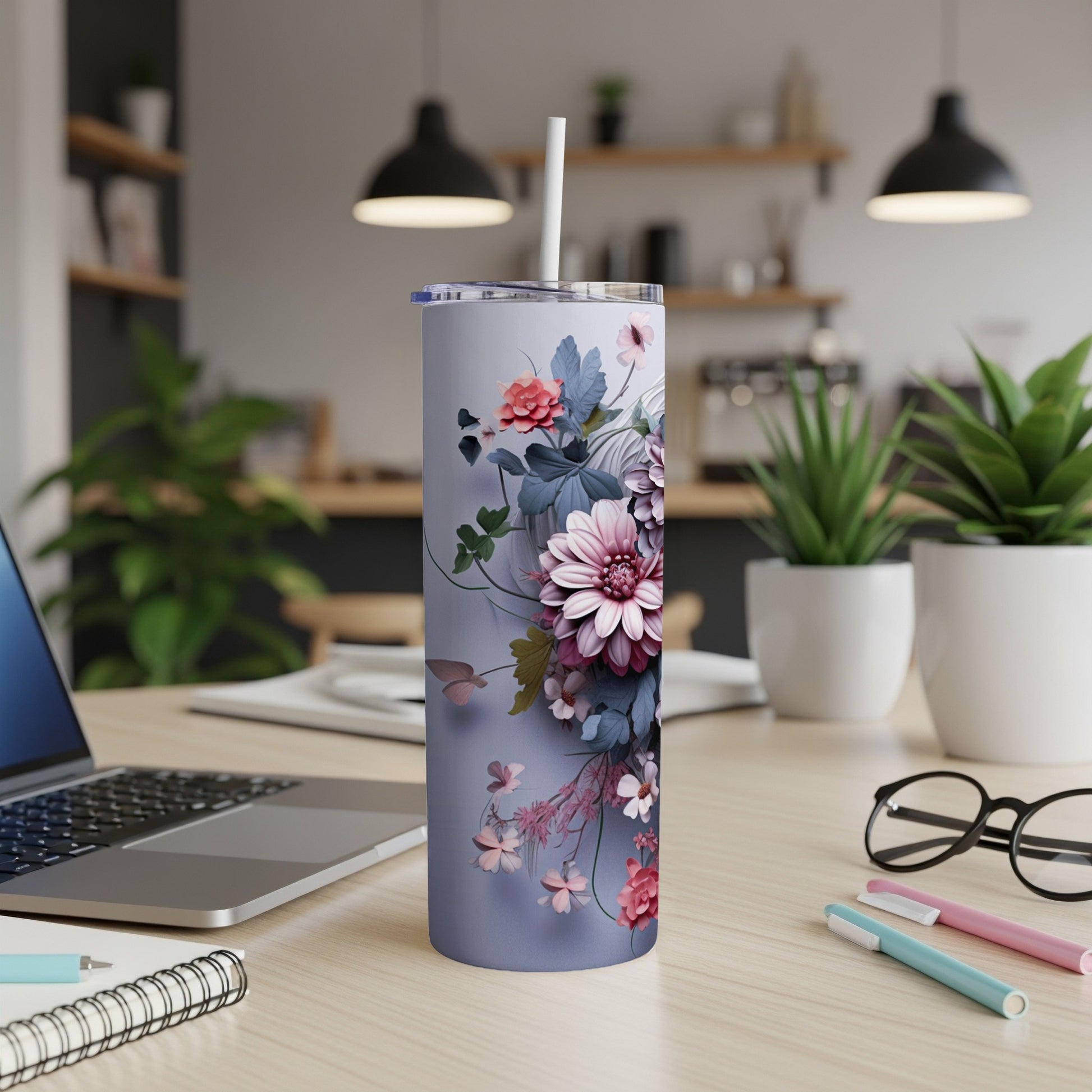 Lavender floral tumbler with straw on a desk with a laptop.