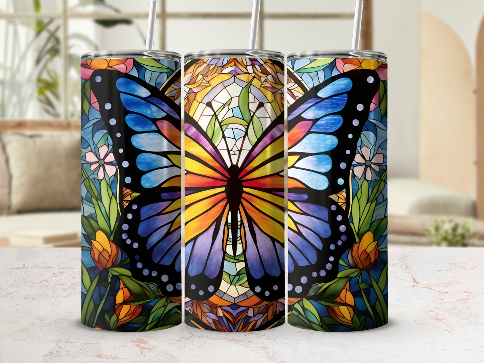 Stained glass butterfly design on three tumblers with straws.