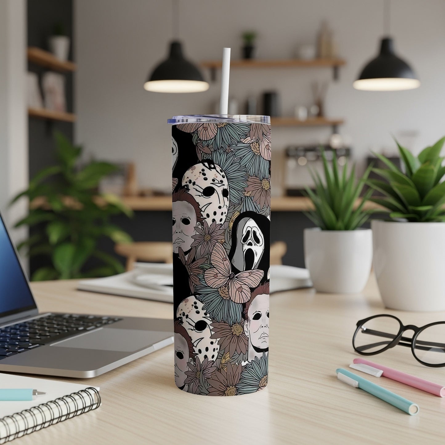 Tumbler with horror movie characters and floral pattern, including a straw.