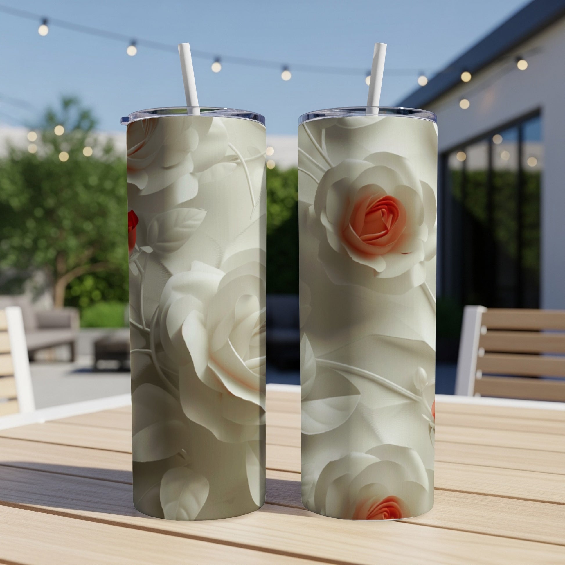 Two cream tumblers with raised white and coral roses, on a wooden table.