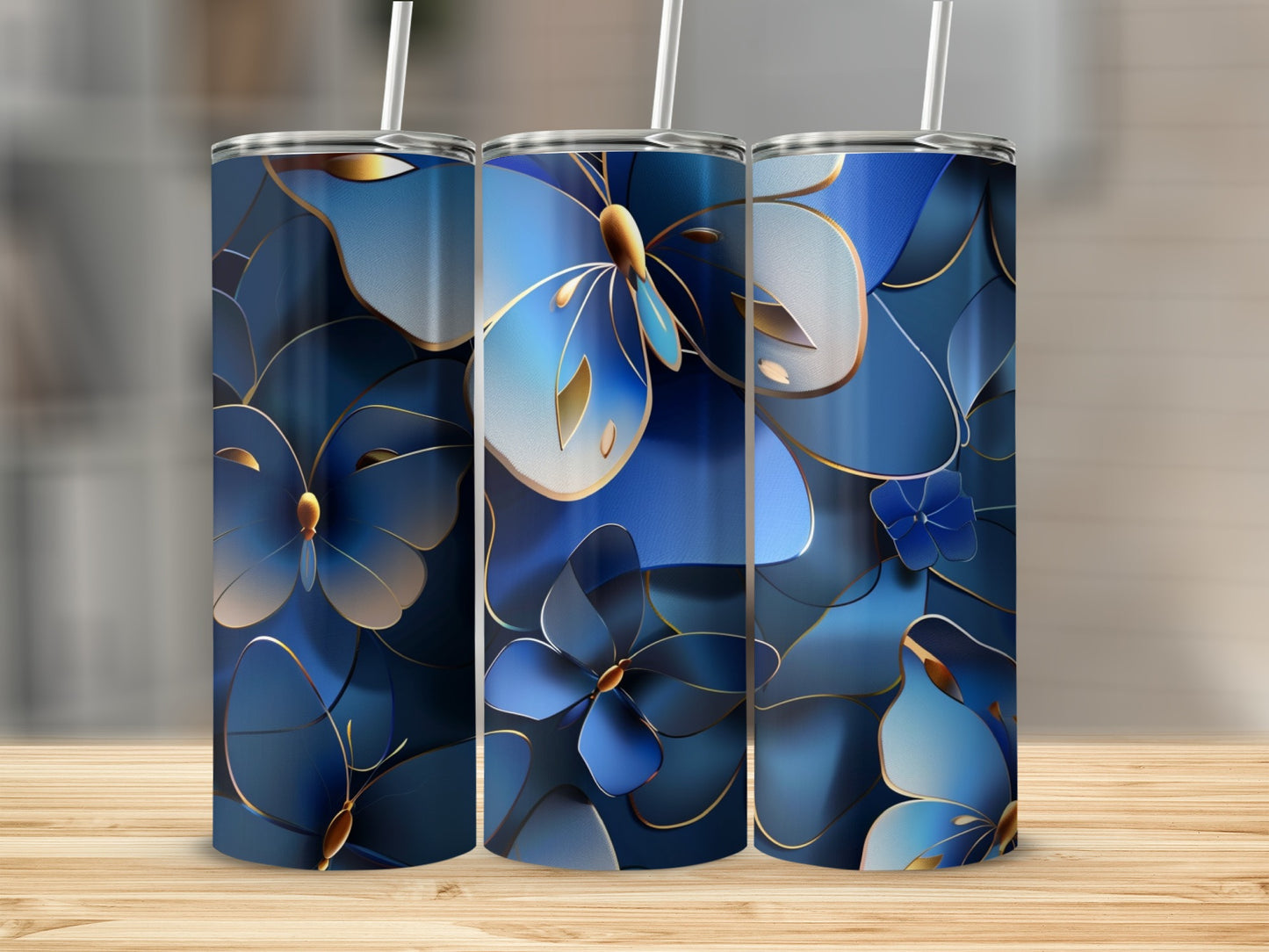 Three blue butterfly and flower patterned tumblers with straws on a wooden surface.