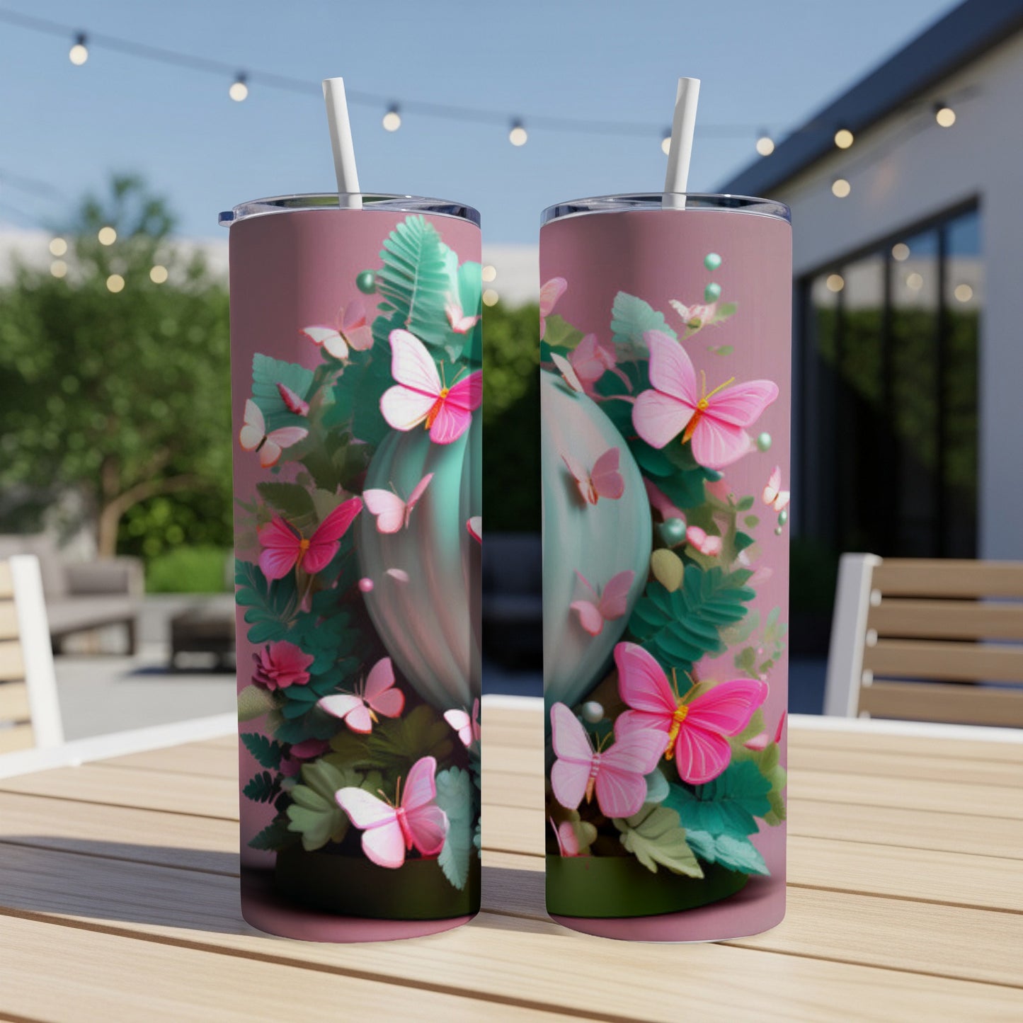 Two pink butterfly-themed tumblers with straws on a wooden table.