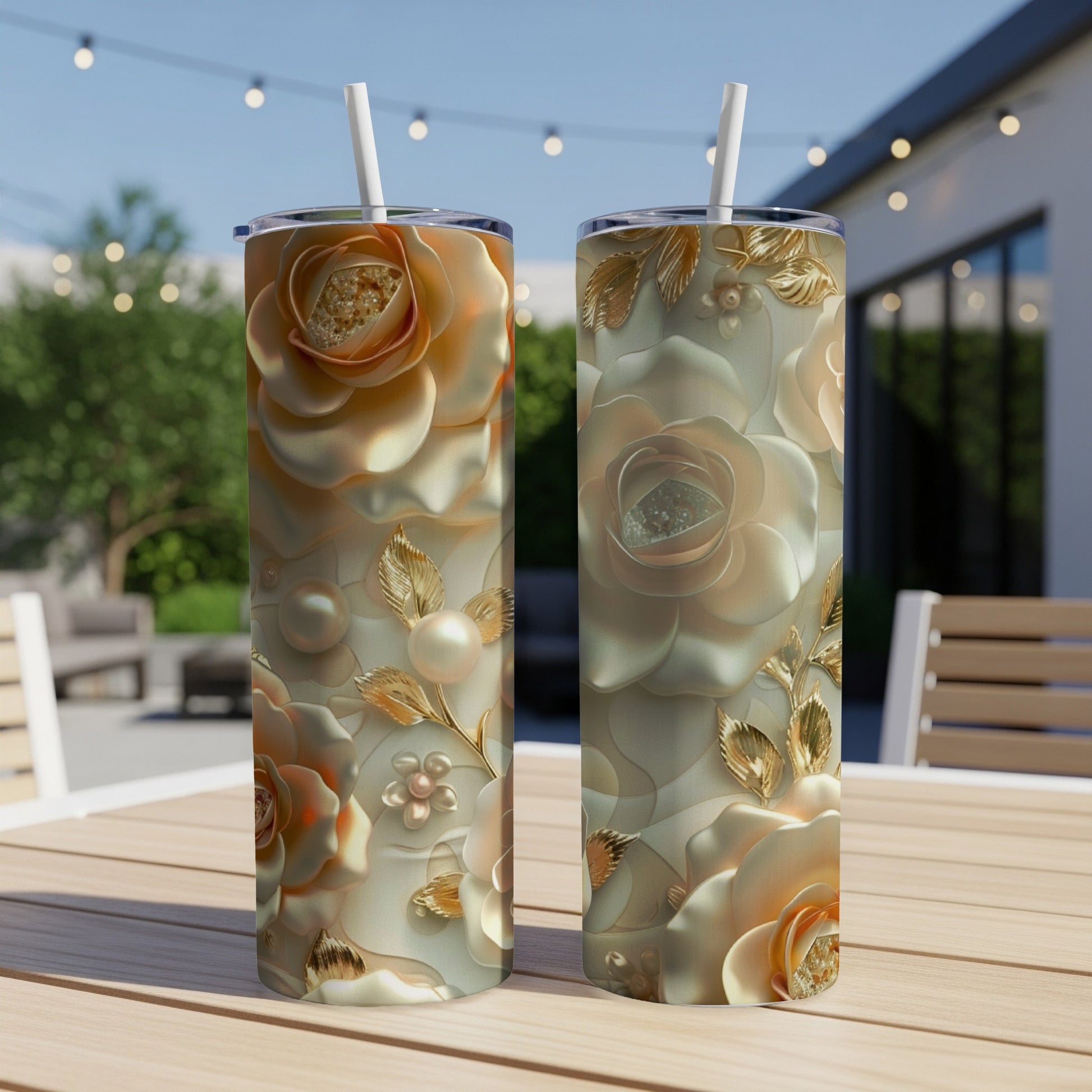 Two tall tumblers with embossed rose and pearl designs on a patio table.