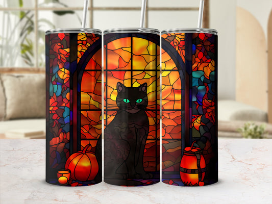 Black cat sits in front of stained-glass window with pumpkins.