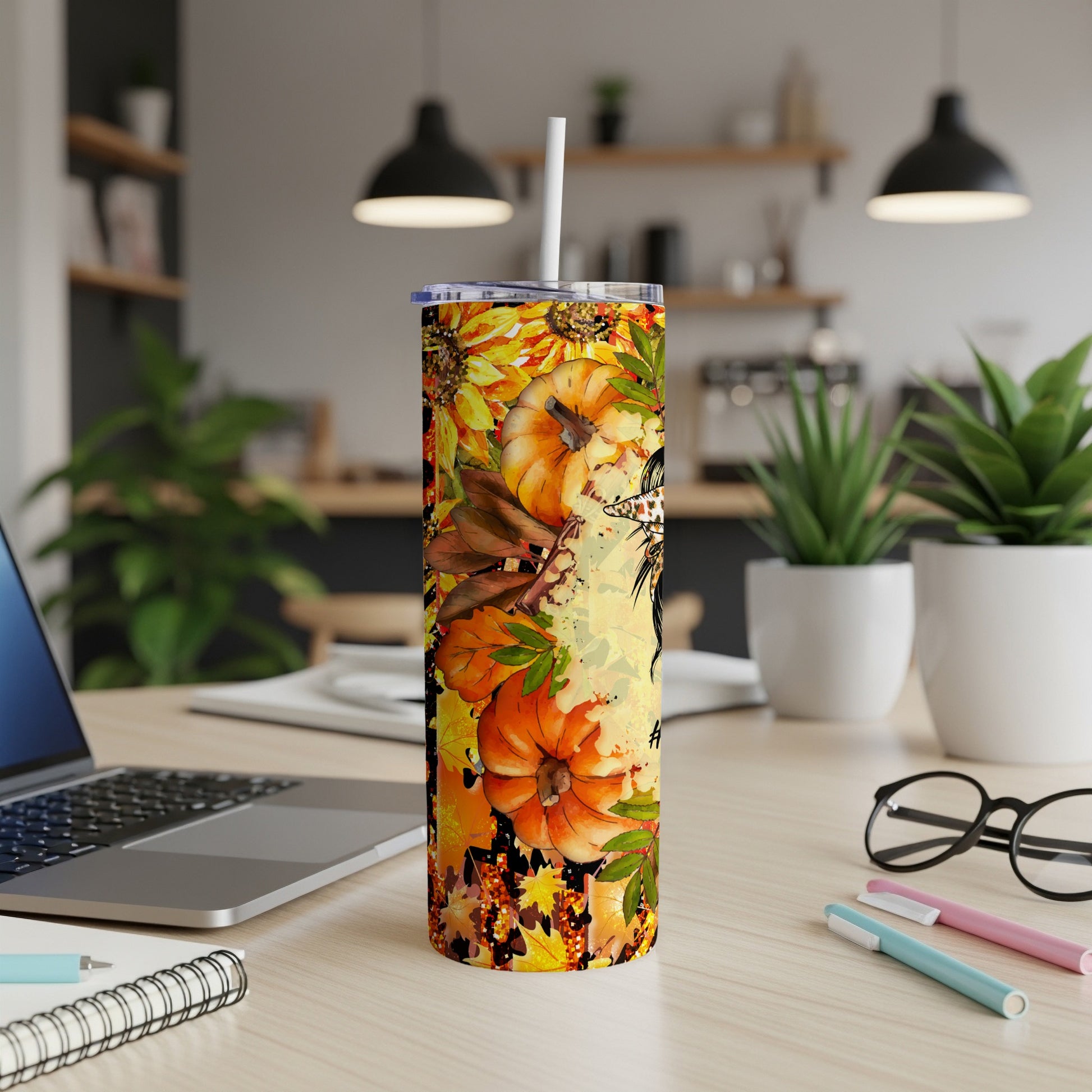 Tumbler with fall leaves, pumpkins, and sunflowers, with a straw.