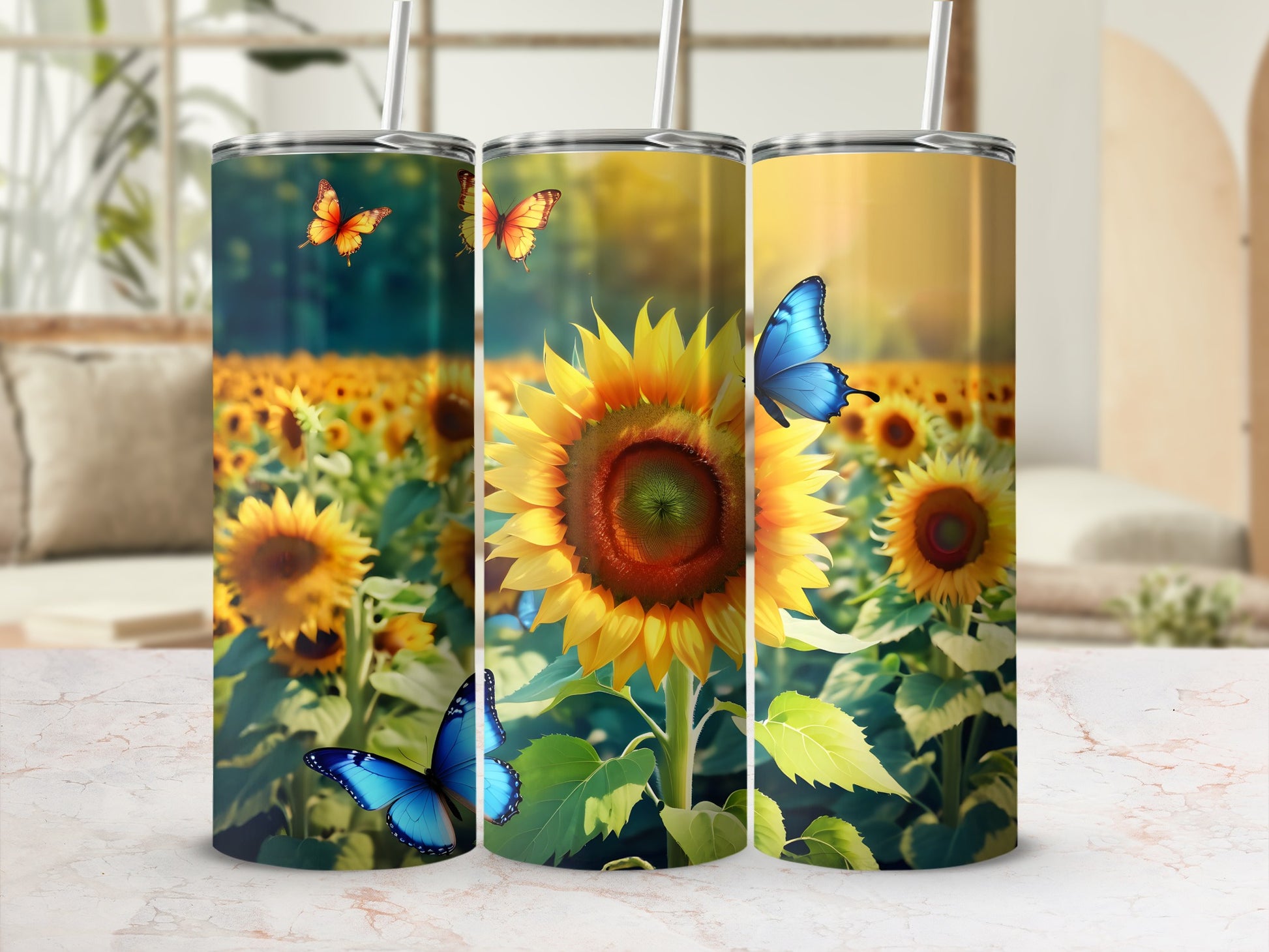 Three tumblers with sunflower and butterfly designs on a marbled surface.