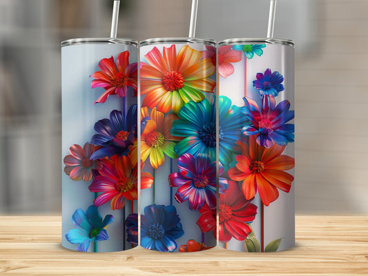 Three tumblers with colorful floral designs arranged on a wooden surface.