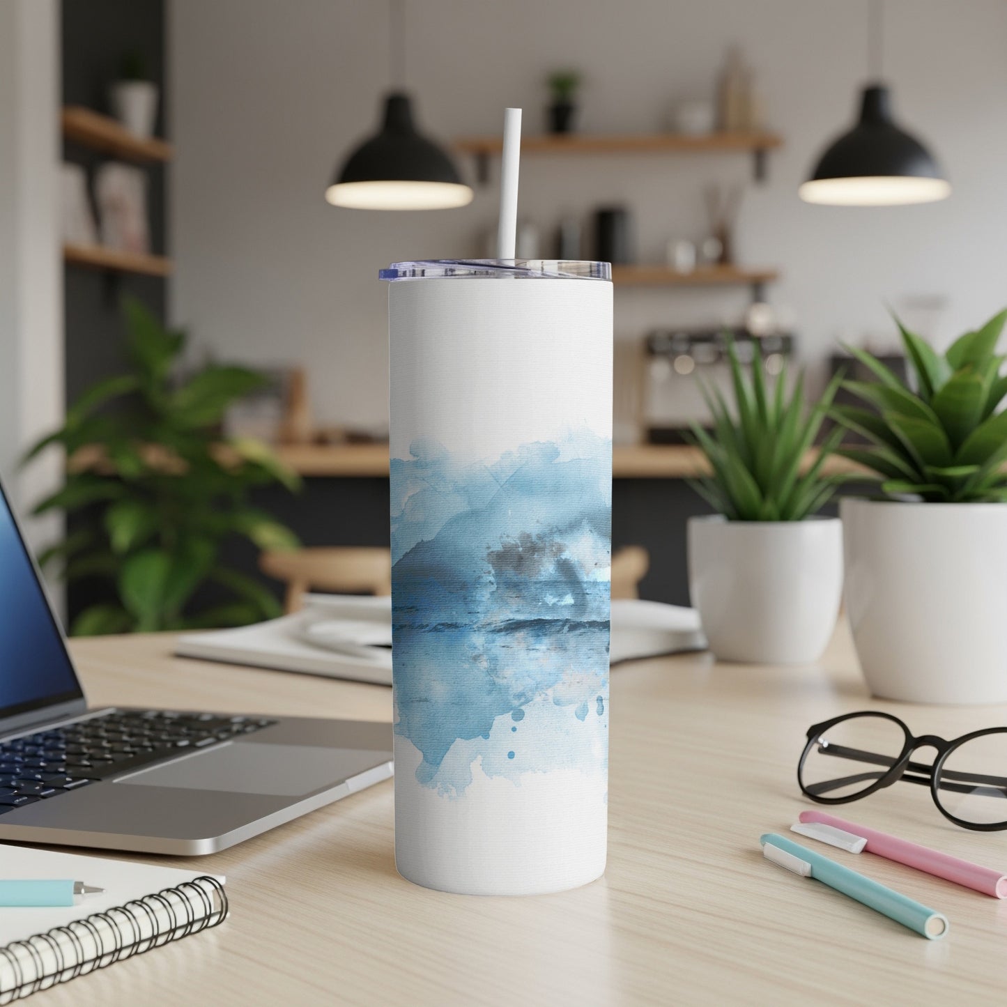 White tumbler with blue watercolor abstract design and straw.