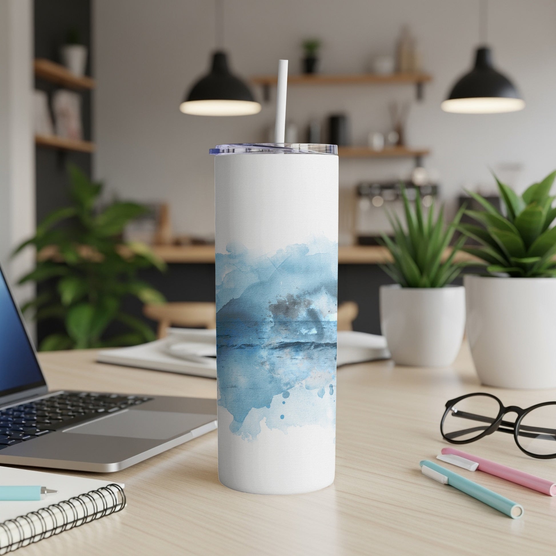 White tumbler with blue watercolor abstract design and straw.