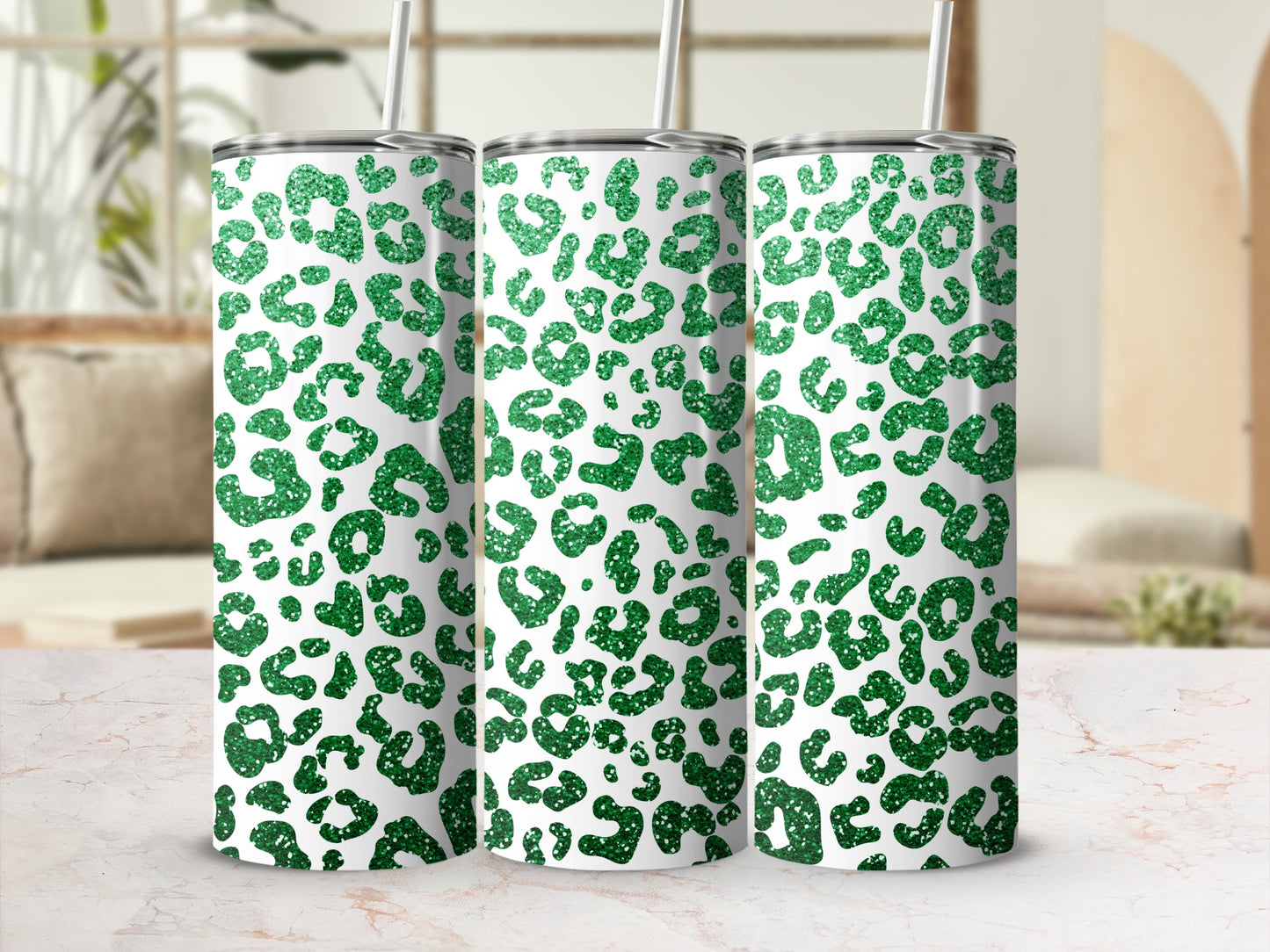 Three tall, glittery green leopard print tumblers with straws.