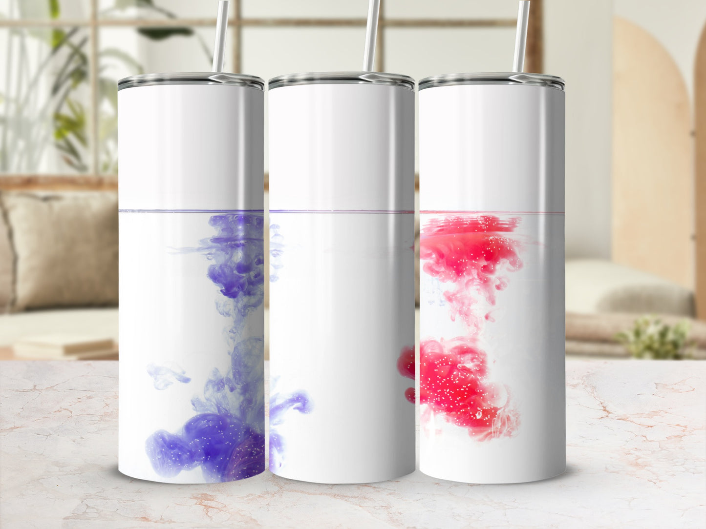 Three tall, white tumblers with colorful ink swirling inside.