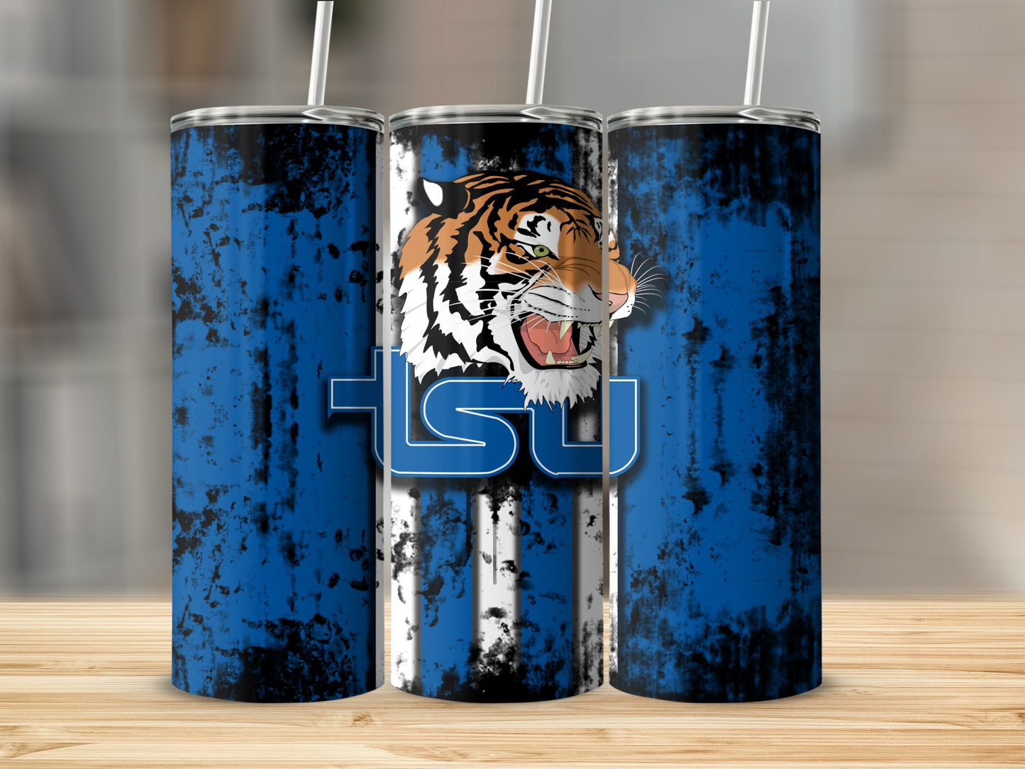 Three tumblers with tiger head and "TSU" logo on blue and black distressed background.