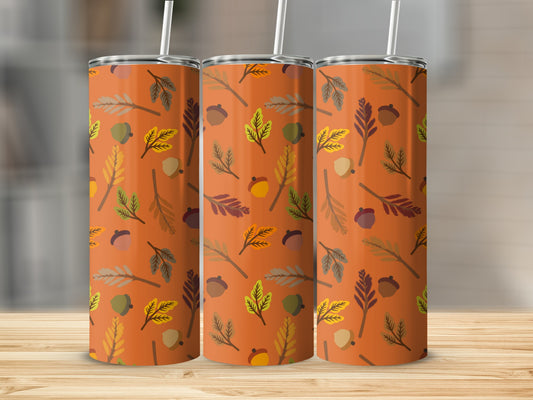 Orange tumbler with fall leaves and acorns pattern.