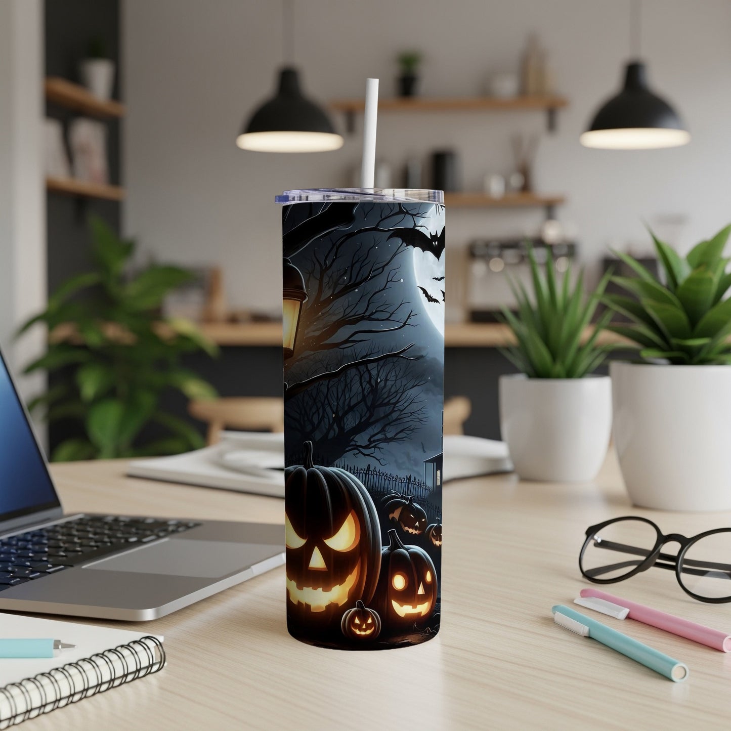 Tumbler with a Halloween design of spooky pumpkins, bats, and a full moon.
