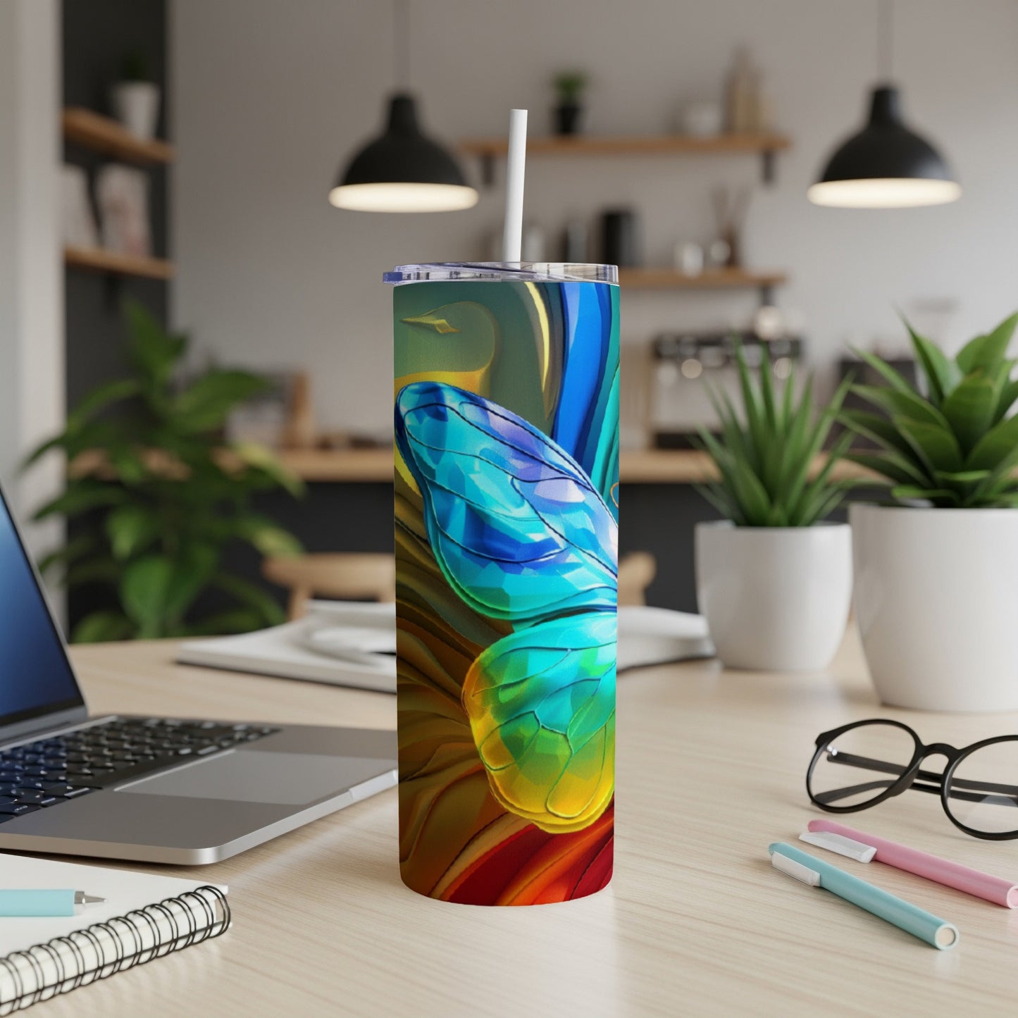 Colorful abstract butterfly wings on a stainless steel tumbler with a straw.