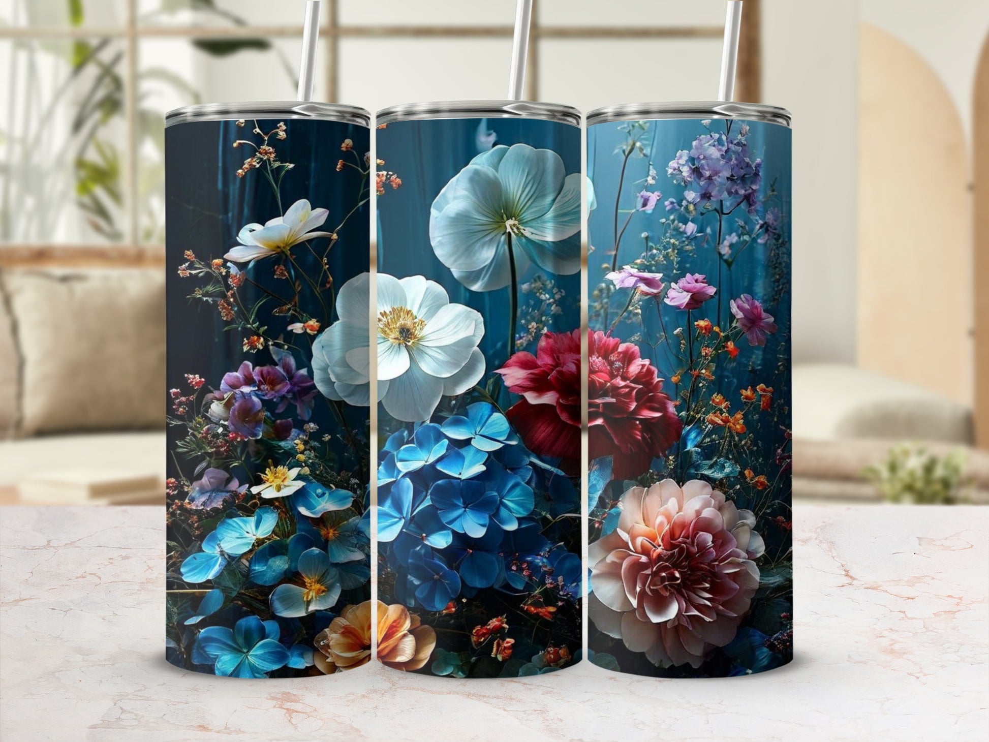 Three floral patterned tumblers with straws arranged side-by-side.