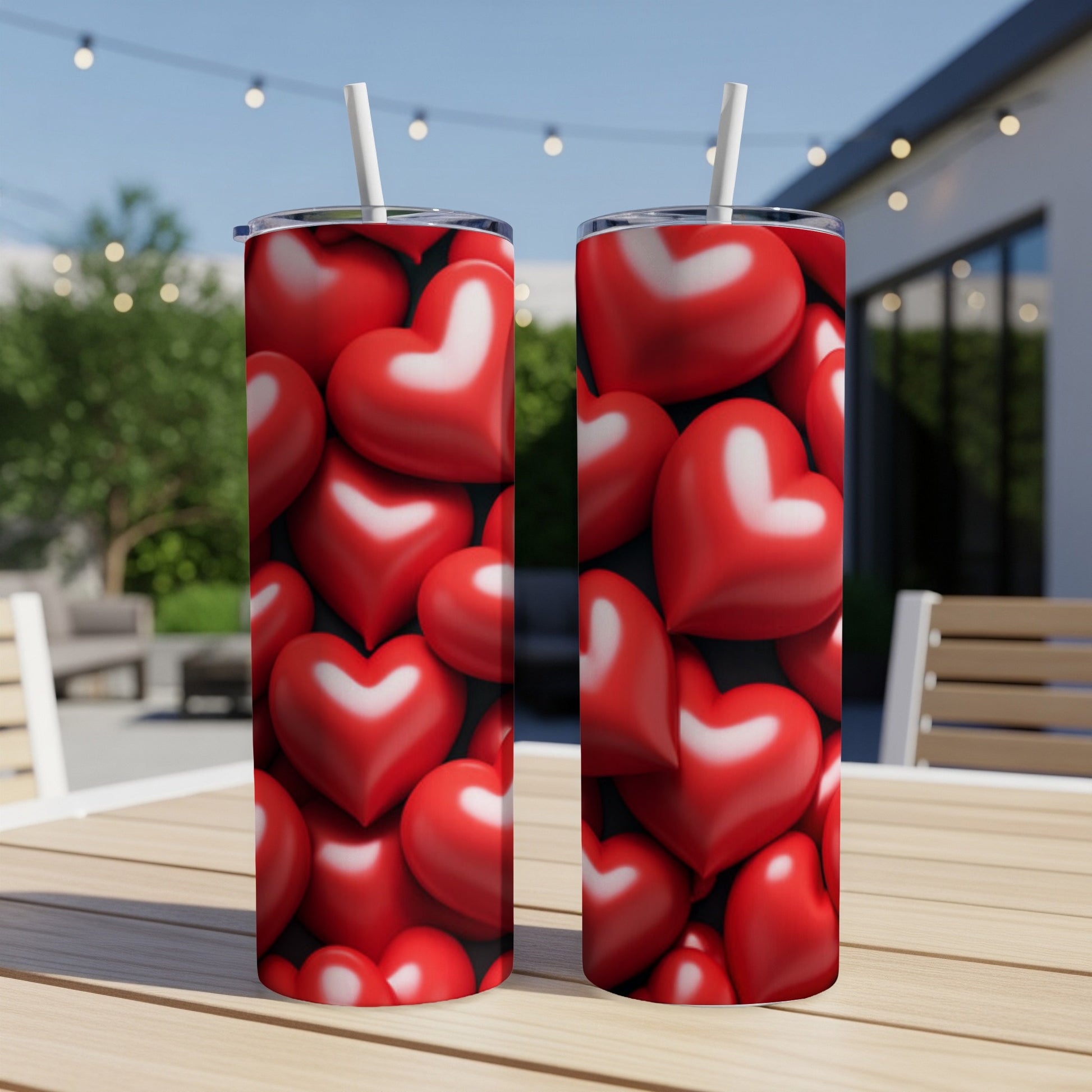 Two tumblers with a repeating pattern of red hearts on a table.
