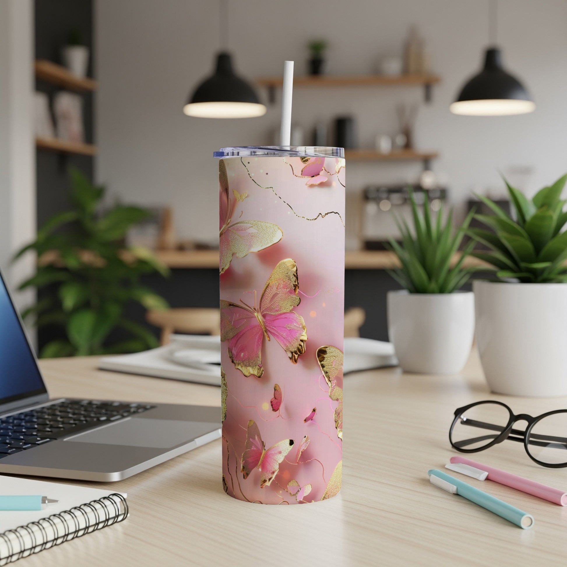 Pink and gold butterfly design on a white tumbler with straw.