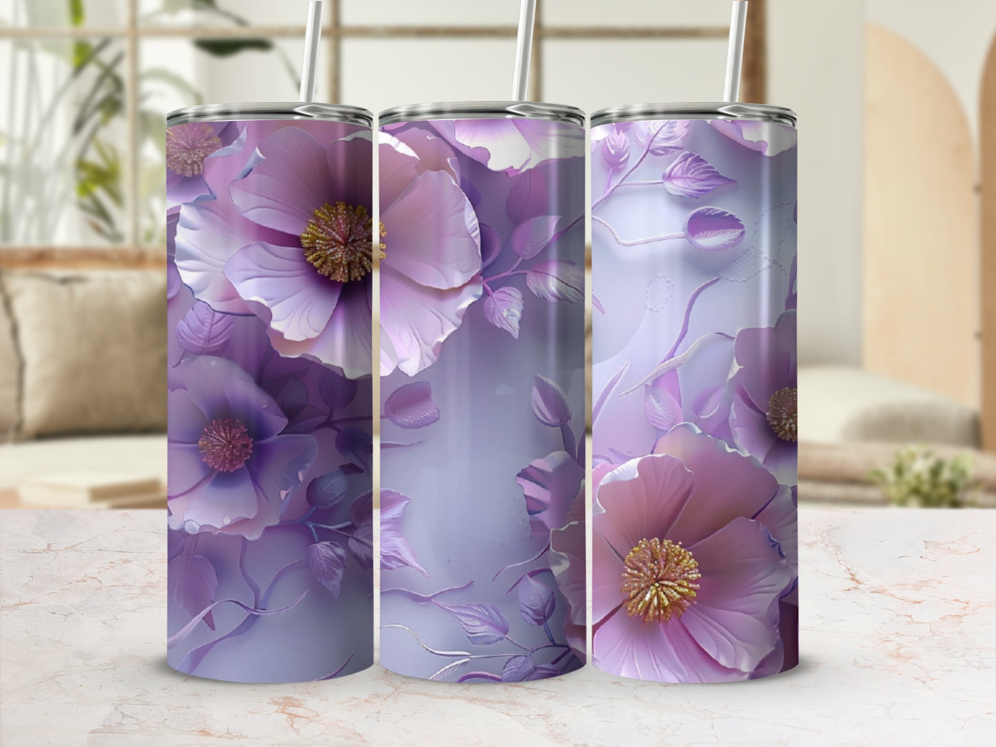 Three purple floral patterned tumblers with straws on a marble surface.