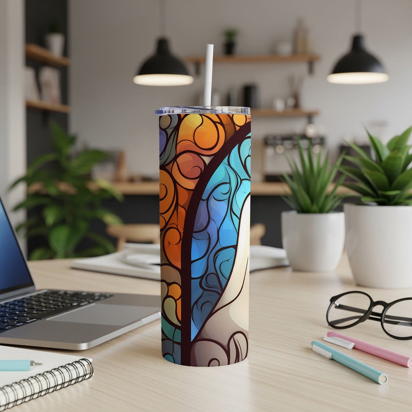 Stained glass pattern tumbler with straw on a desk.