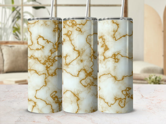 Three white marble tumblers with gold veining and straws on a marble surface.