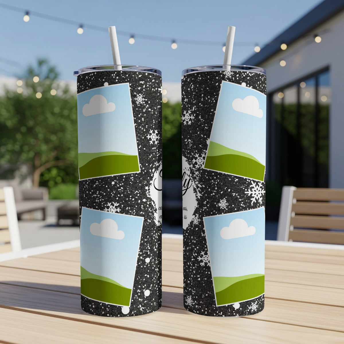 Two tumblers with a black glitter design, snowflakes, and photo frames are on a table.