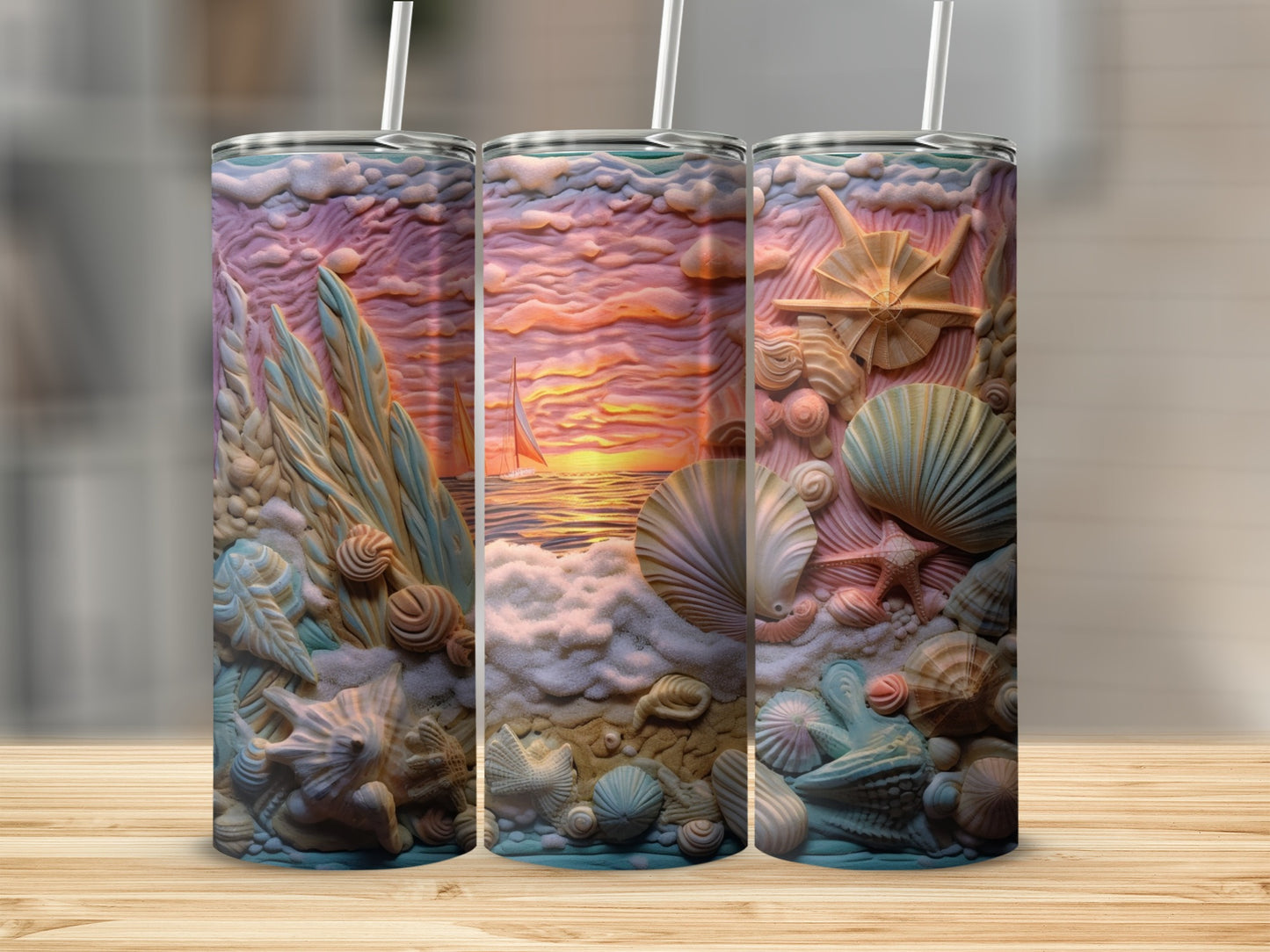 Three tumblers with a beach and seashell relief design, sunset in the background.