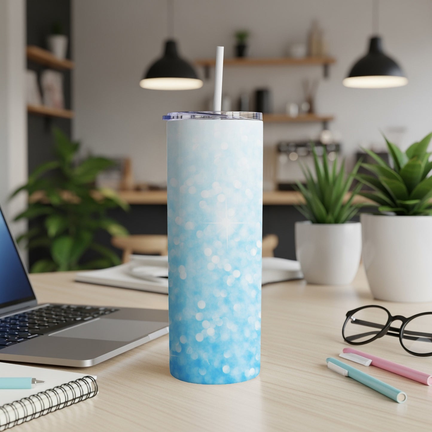 Blue glitter skinny tumbler with white straw on desk.