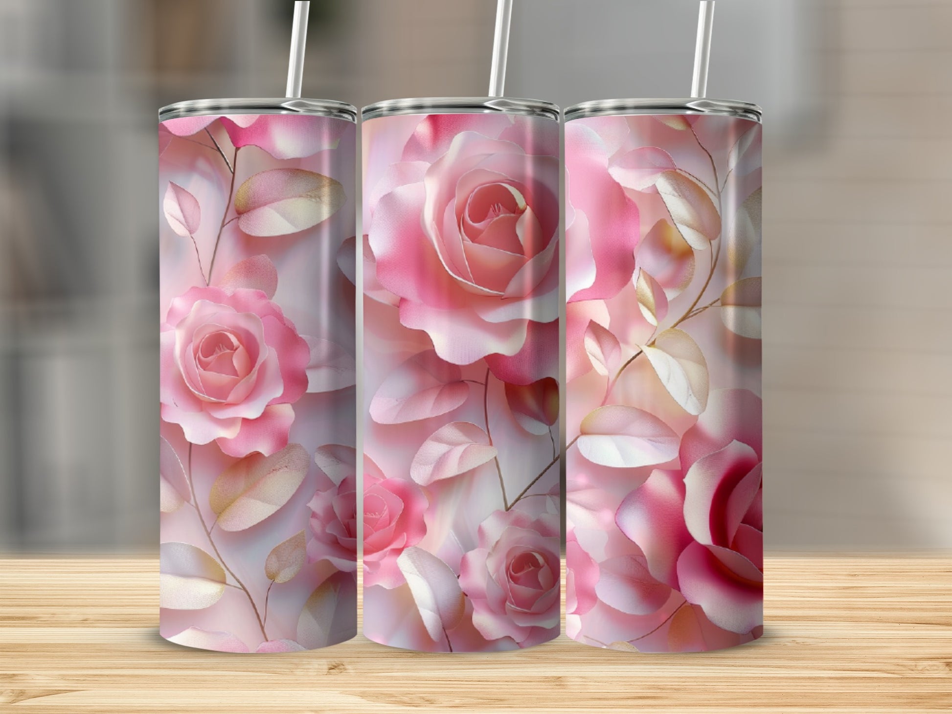 Three tumblers with a pink rose and leaf pattern on a wooden surface.