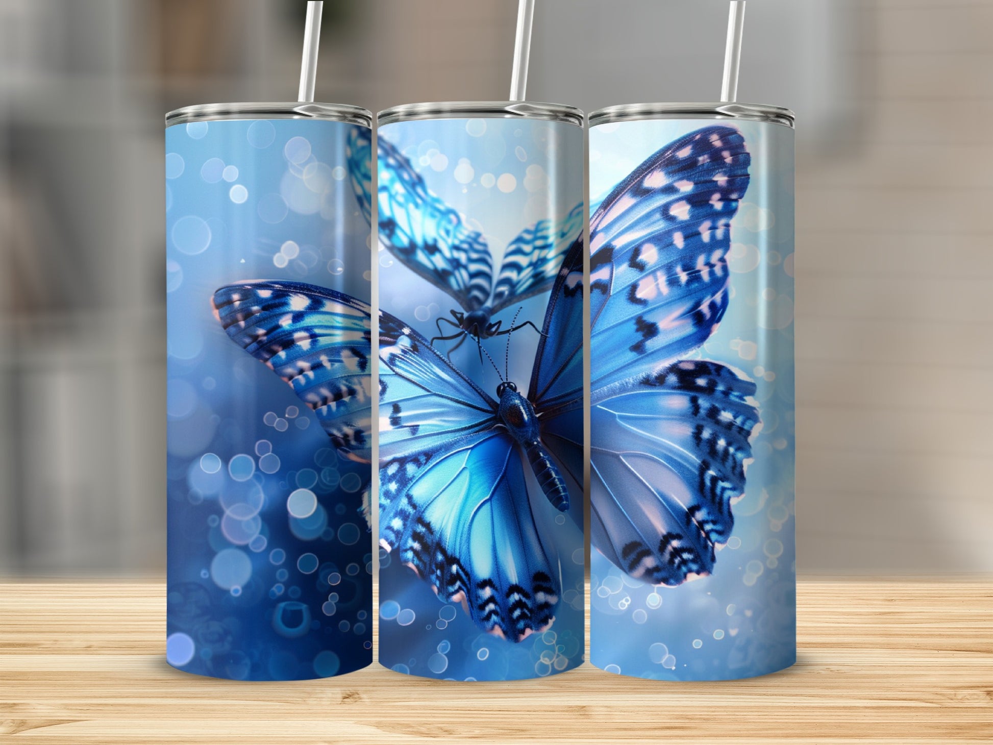 Three tumblers featuring blue butterflies with bokeh background effects.