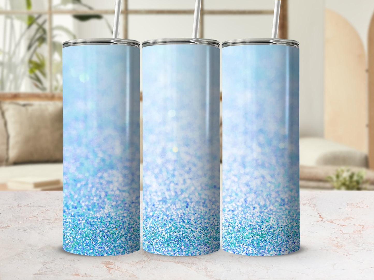 Three glitter-covered tumblers with blue ombre gradient and straws.