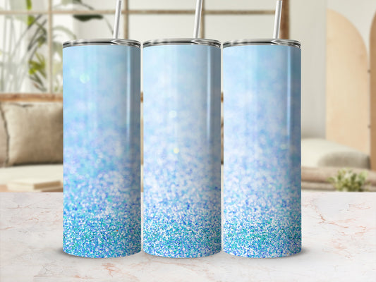 Three glitter-covered tumblers with blue ombre gradient and straws.