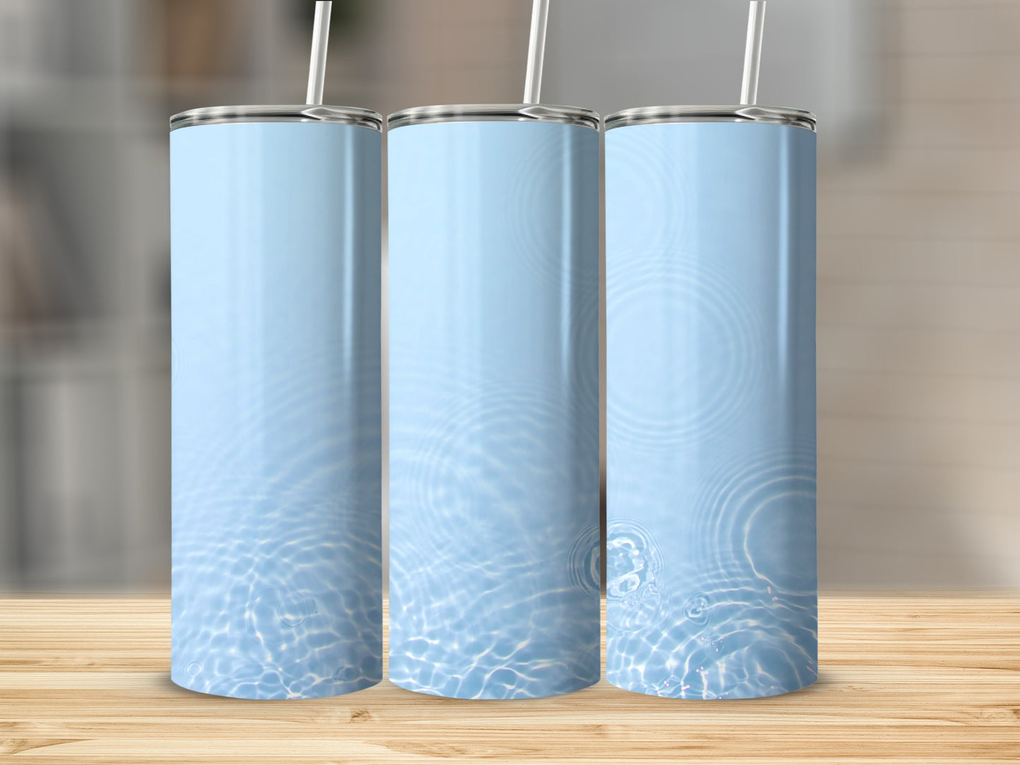 Three tall, light blue tumblers with a water ripple design on a wooden surface.