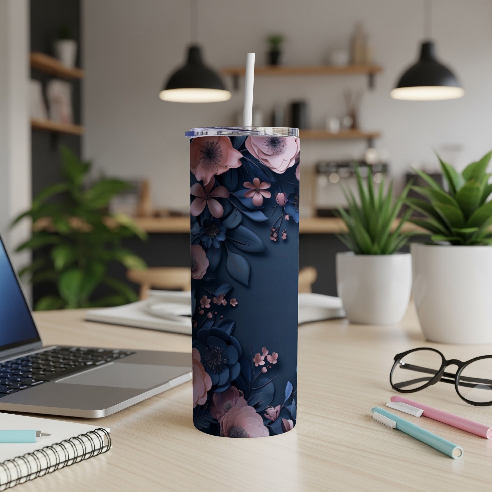 Dark blue floral tumbler with a white straw and lid, on a desk.
