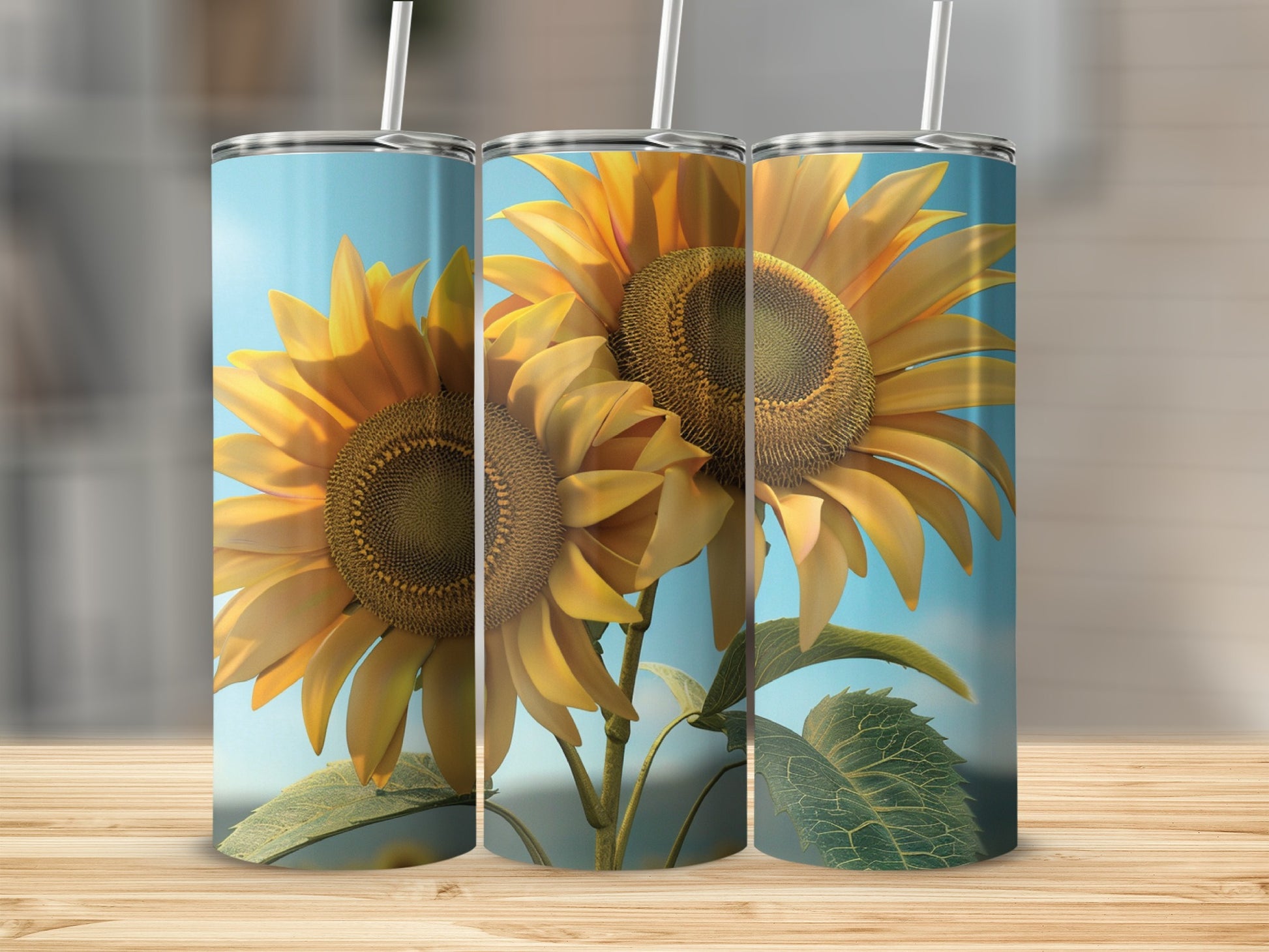 Three sunflowers on blue gradient tumblers with straws on a wooden surface.