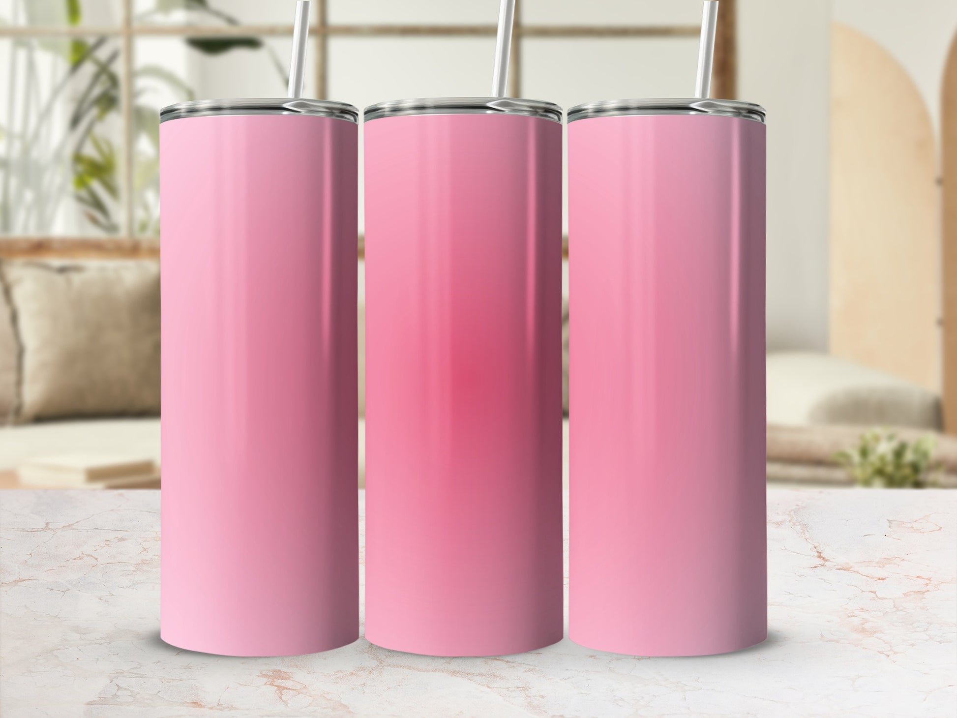 Three pink tumblers with straws on a marbled surface.