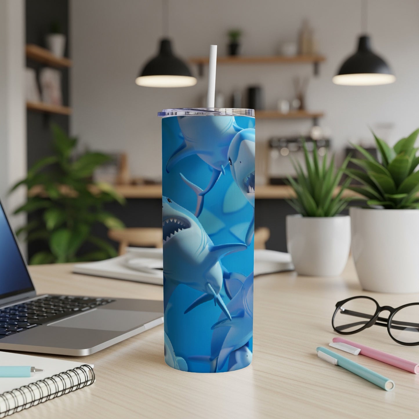 Blue tumbler with a repeating pattern of cartoon sharks with white straws.