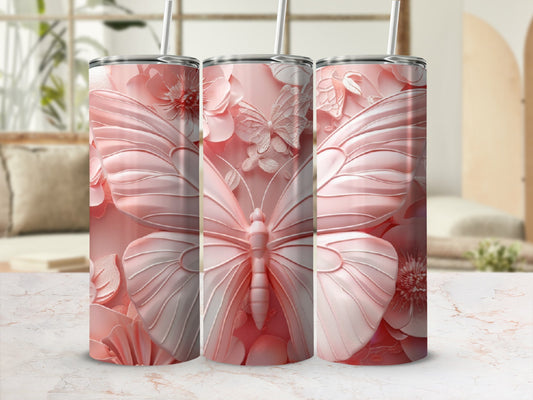 Three pink butterfly and floral pattern tumblers with straws, displayed on a marble surface.