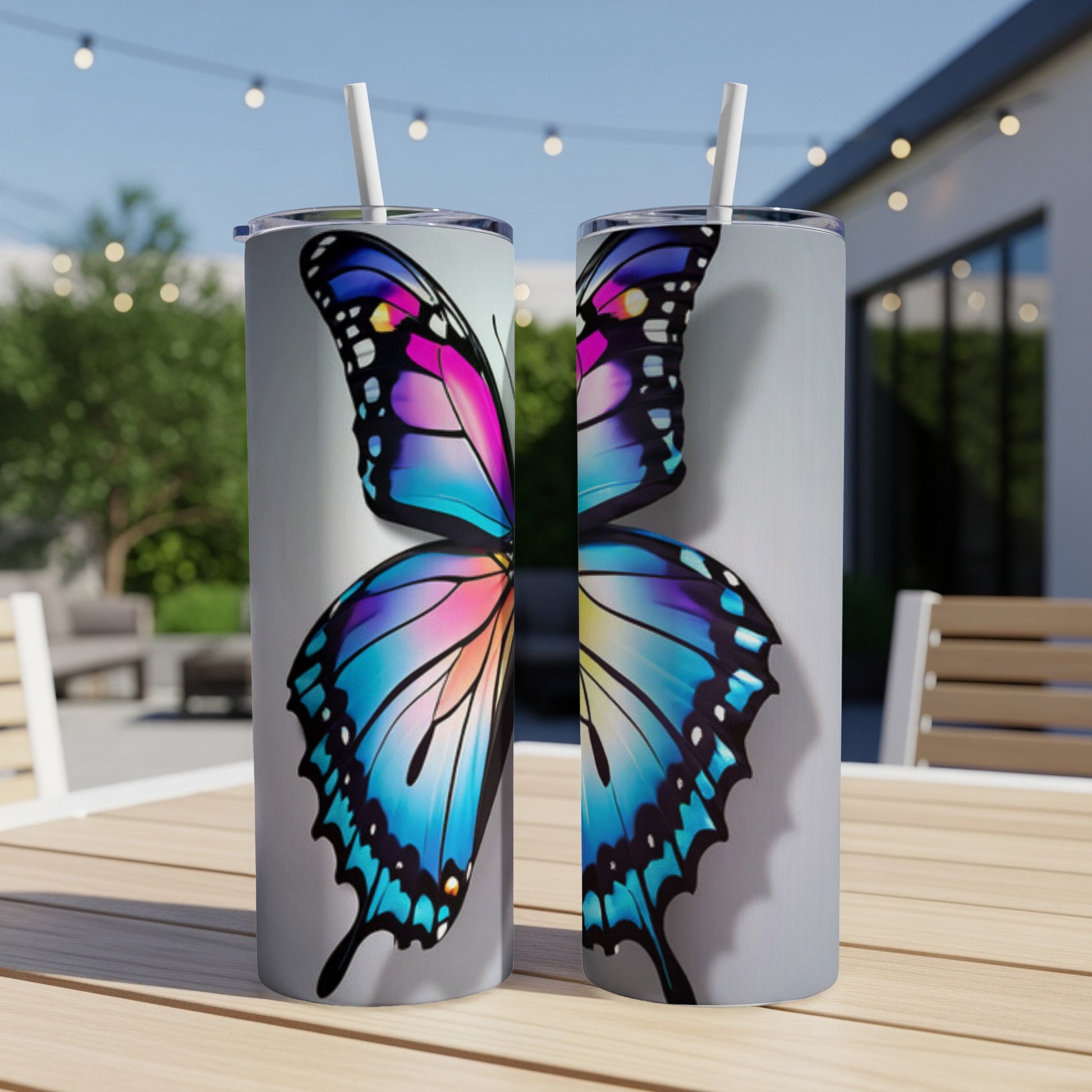 Two tumblers with a colorful butterfly wing design on a table.