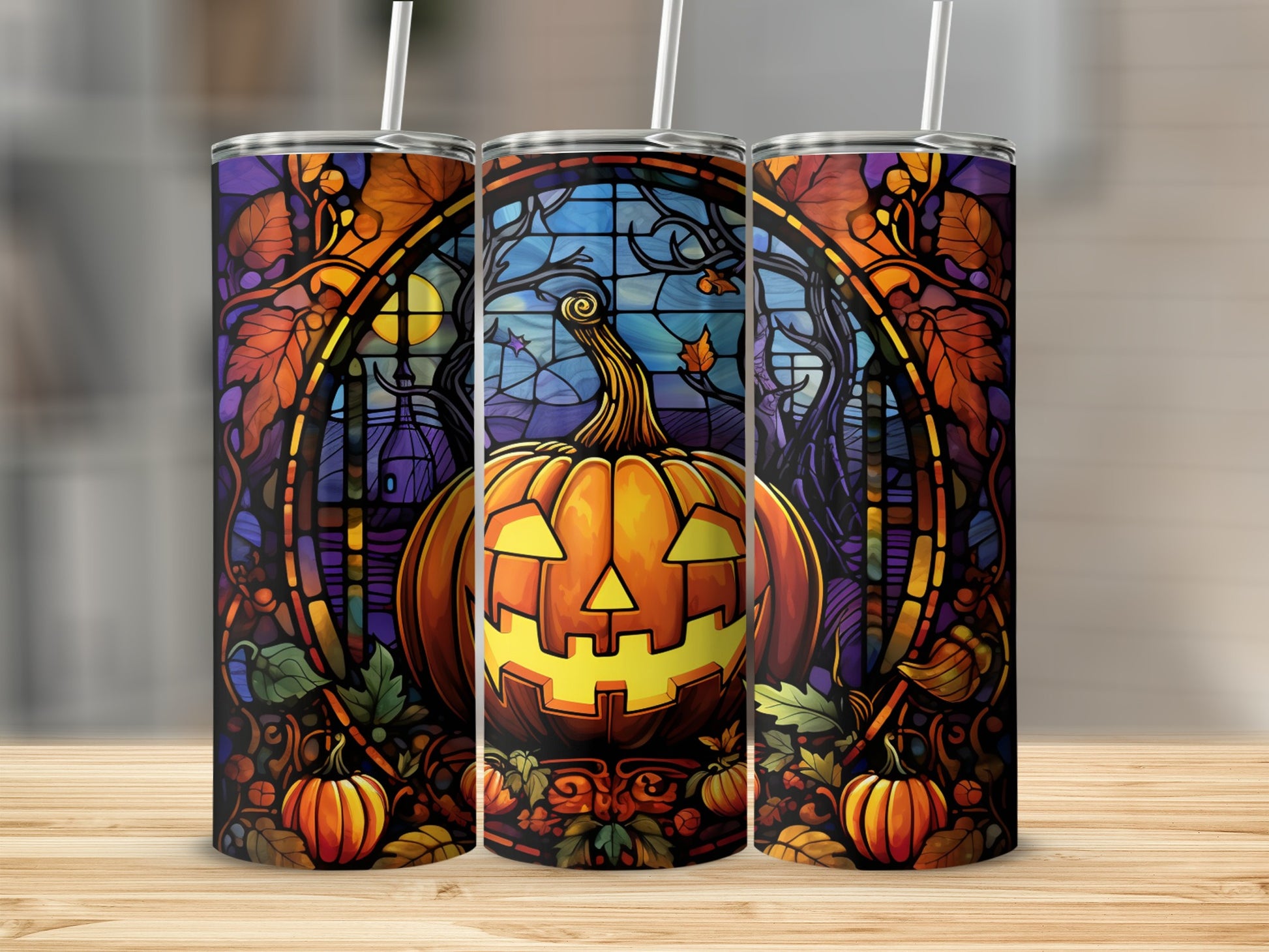 Stained glass pumpkin design on three tumblers with straws.