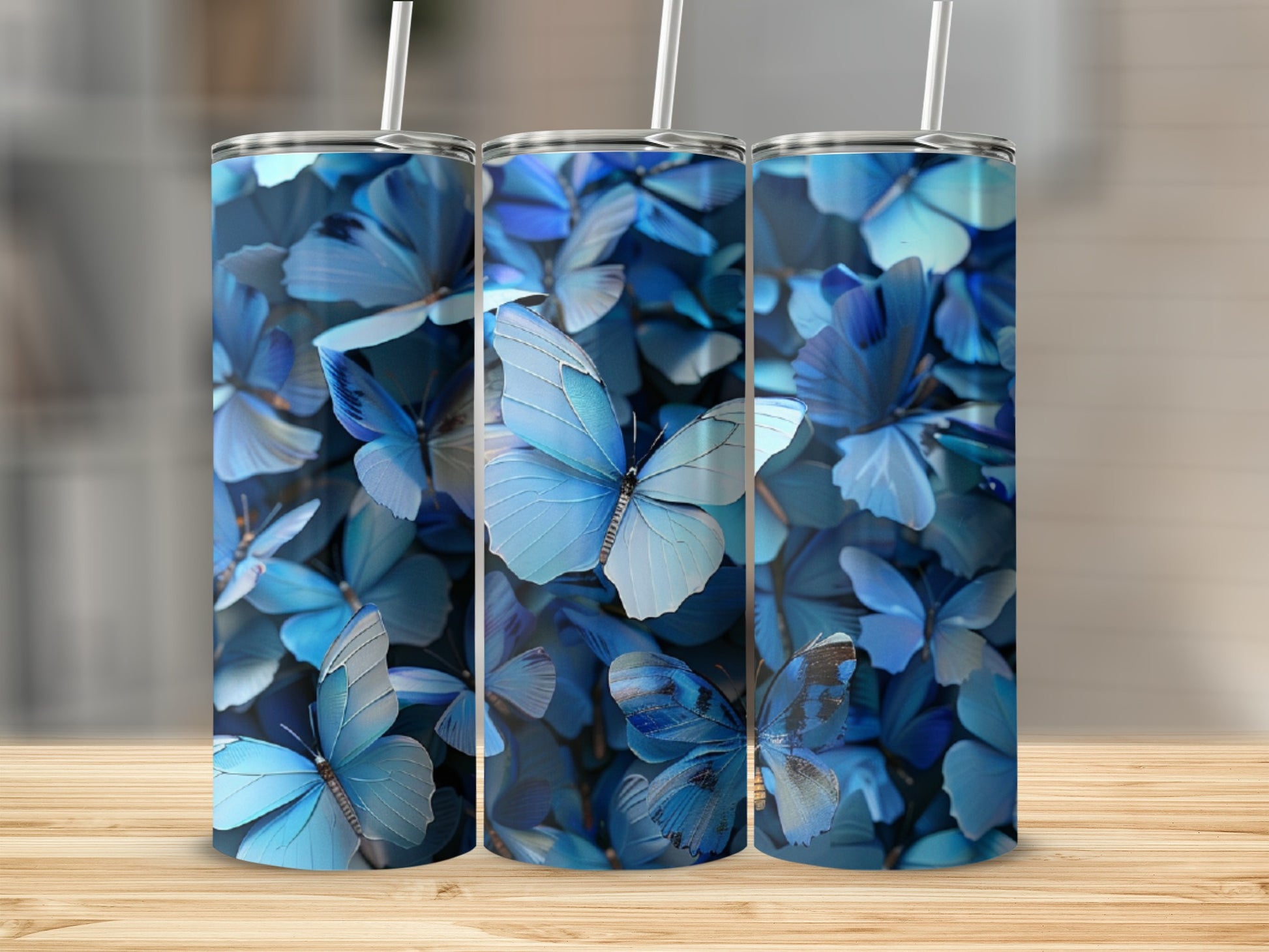 Three tumblers featuring a blue butterfly pattern on a wooden surface.