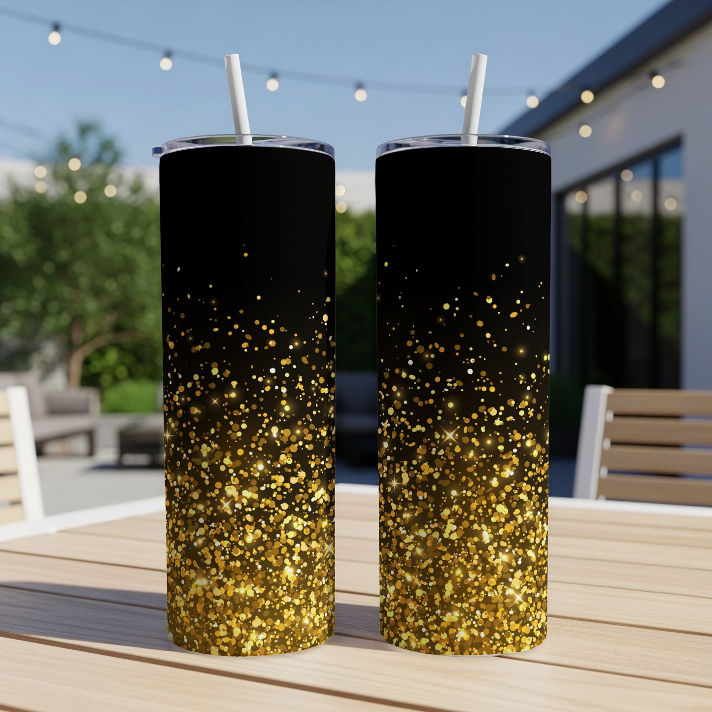 Two black tumblers with gold glitter accents on a wooden table.