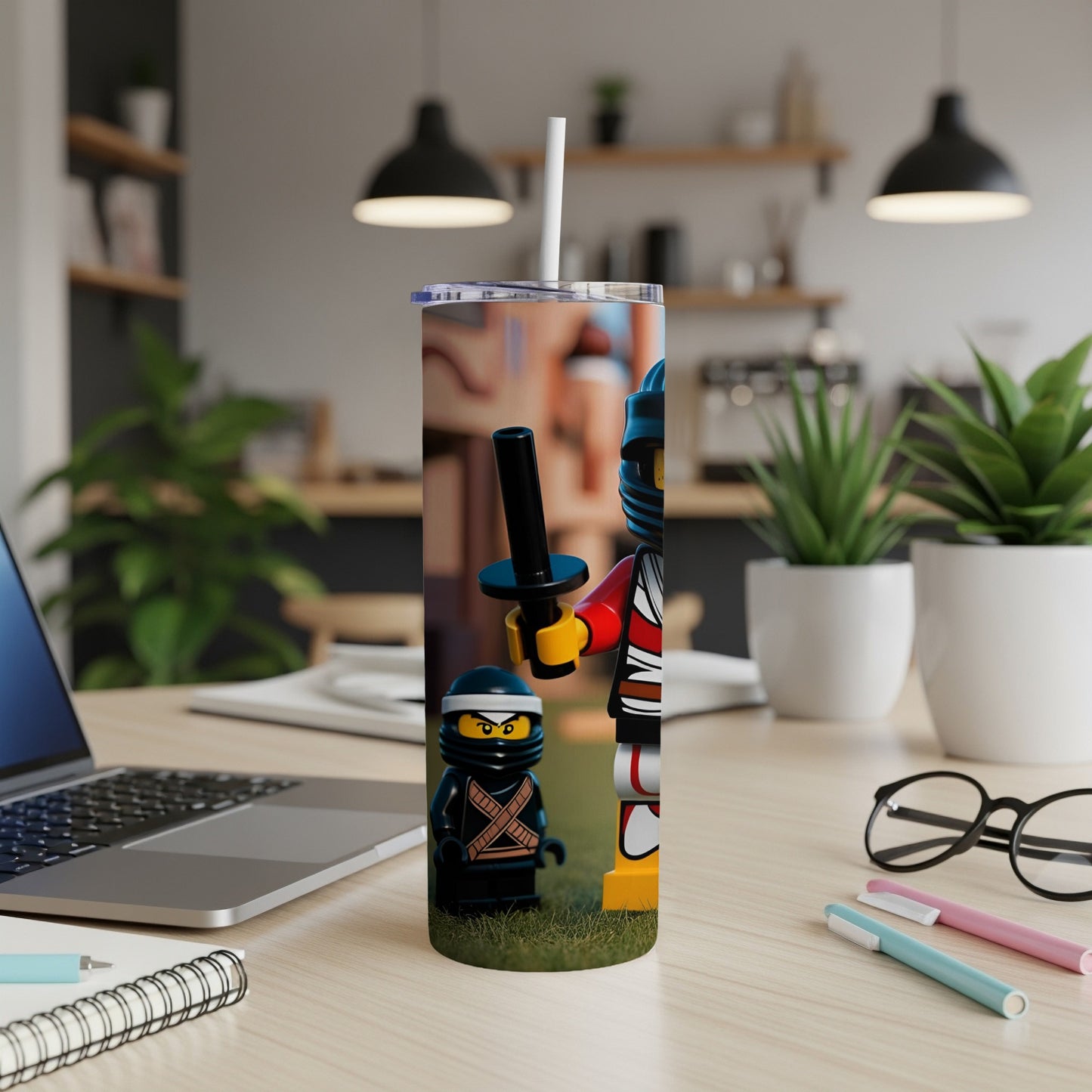 Ninjago minifigures on a tumbler with a laptop and art supplies.